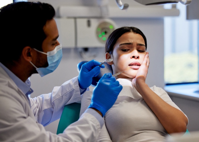 Patient experiencing severe tooth pain during a dental emergency visit in St. Louis, MO.