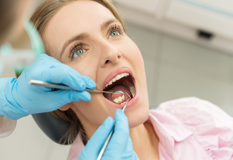 A young woman undergoing plaque treatment in a dental clinic in St. Louis, MO