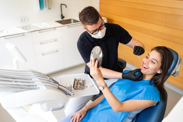 Dentist explaining dental bonding and veneers during a cosmetic dentistry visit in St. Louis, MO.